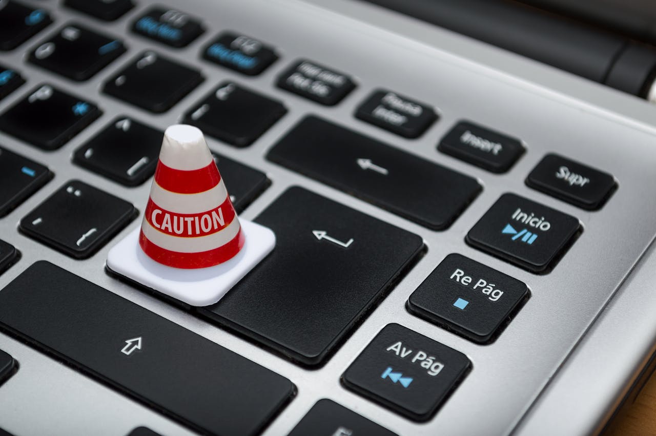 who-we-are Miniature caution cone on a computer keyboard symbolizing data security and control.